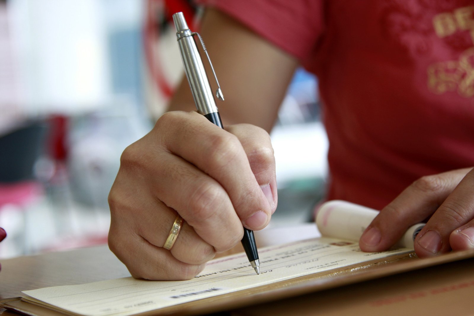 Close,Up,Of,A,Woman,Signing,A,Check,Cheque